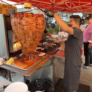 The trompo. Notice that he slices off some pineapple and flings it right into the taco.