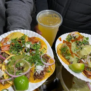 two plates of tacos and a drink