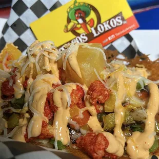 Bacon wrapped hotdog with bell peppers, pineapple chunks, hot Cheetos, cheese and our famous chipotle cream sauce