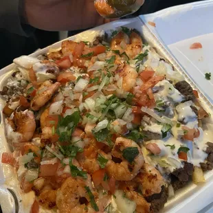 a hand holding a taco in a styrofoam container