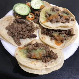 a plate of tacos and cucumbers