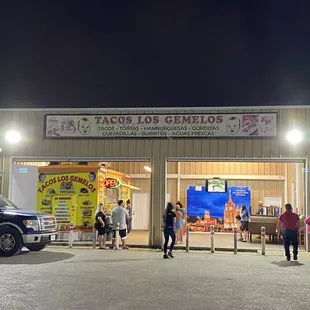 people standing in front of a taco store