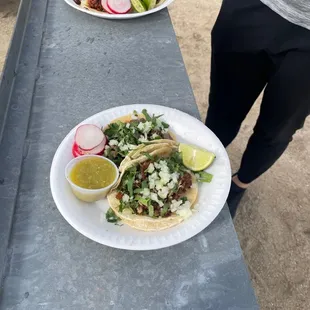 two plates of tacos on a picnic table