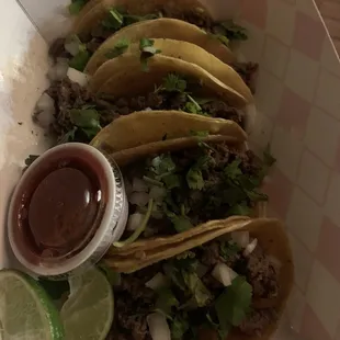 a plate of tacos with a side of salsa