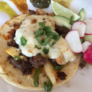 Choriqueso with a side of all the sauces.