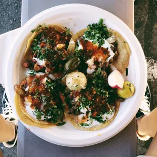 two al pastor and two carne asada tacos w/ everything plus sour cream.