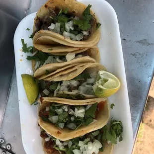 Two chicharones, two cabezas, and one carne asada tacos. Tortillas are warm and slightly crispy.