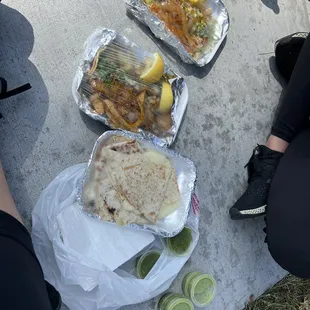 a person sitting on the ground with a plate of food