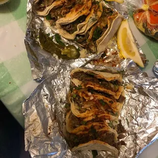 a variety of tacoss on tin foil