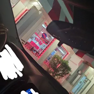 a view of a taco restaurant through the windshield of a car