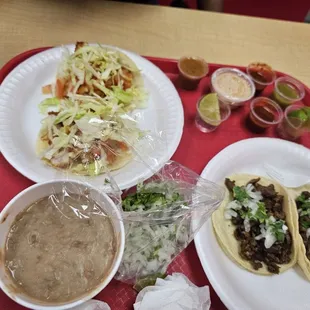 Fried fish tacos, beans, Cilantro onions, and carne asada  tacos the red one is extremely hot and good