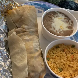 Chorizo egg and cheese burrito with a side of rice and beans