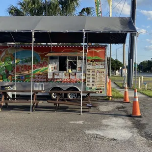 a taco stand with tables and chairs