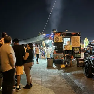 people standing in line at a food truck