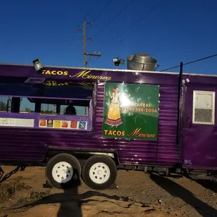 a purple food truck parked in the desert