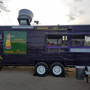 a man sitting at a table in front of a taco truck