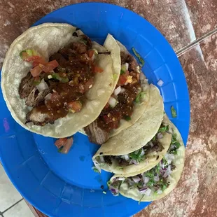 Carnitas and carne asada tacos with salsa on top