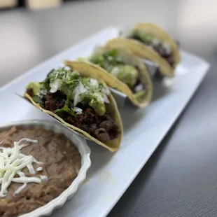 three tacoss on a white plate