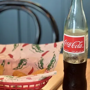 a bottle of coke and a basket of chips