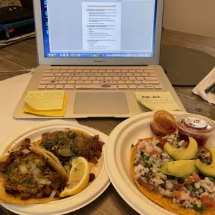 two plates of tacos and a laptop