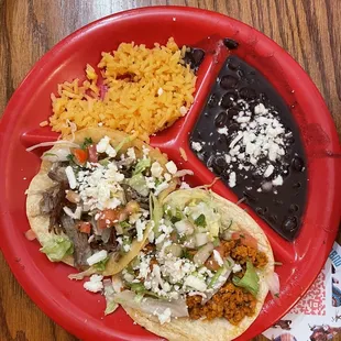 Two tacos, rice, with black beans that had cheese on top.