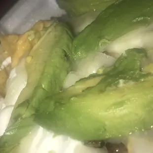 a close up of a taco with cheese and avocado