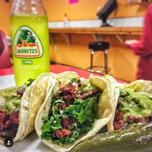 a plate of tacos with a pickle
