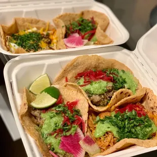 a variety of tacos in a styrofoam container
