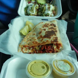 Both Tacos de asada bomba style and chicken quesadilla with guacamole sauce and salsa verde