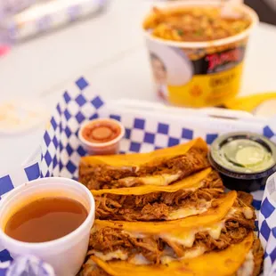 a basket of tacos and a cup of sauce
