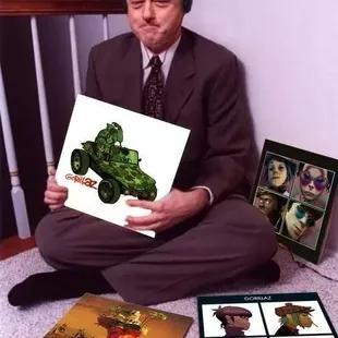 a man in a suit sitting on the floor holding a book