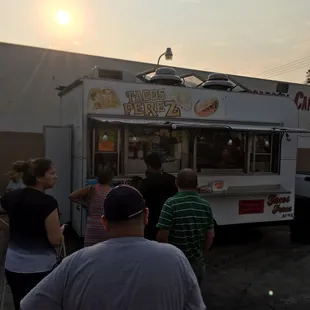 a line of people waiting to order food from a food truck