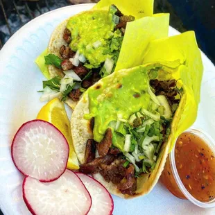 ASADA TACOS AL CARBÓN CON TORTILLAS HECHAS A MANO. Fire grilled Asada tacos with handmade tortillas and fresh guacamole.