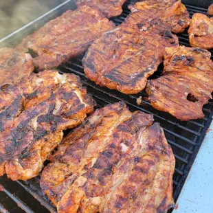 a close up of meat cooking on a grill