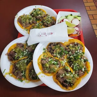 three plates of tacos on a tray
