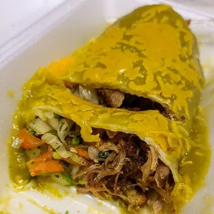a close up of a burrito in a styrofoam container