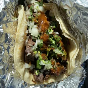 Barbacoa taco with cilantro &amp; onions with red salsa