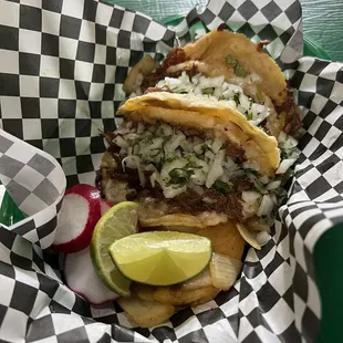 a basket of tacos and a drink