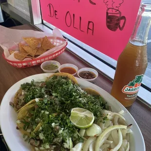 Tacos chips salsas and a jarrito