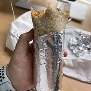 a hand holding a burrito