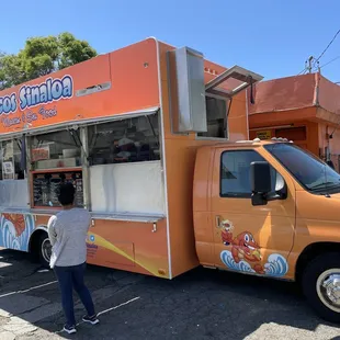 a woman standing in front of a food truck