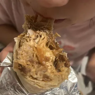 a child eating a burrito