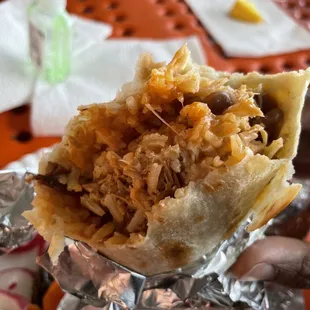 a hand holding a burrito