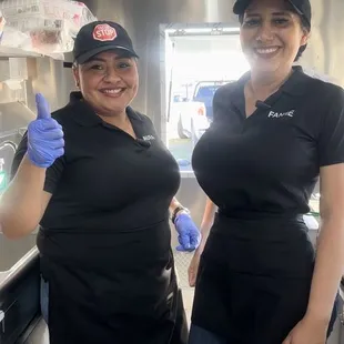 two women standing in a food truck