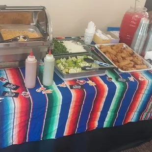 Condiment station: Beans, rice, salsa, limes, cilantro and onions. Complementary watermelon Agua Fresca.