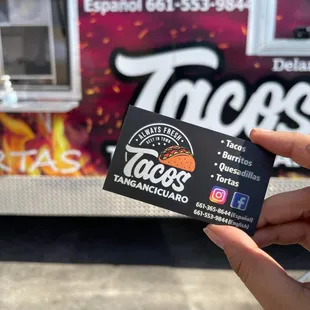 a hand holding a taco truck