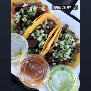 a plate of tacos with sauces