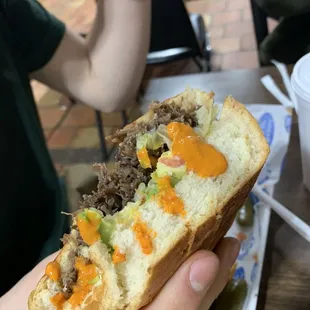 a hand holding a sandwich