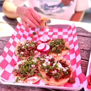 a person putting toppings on a taco