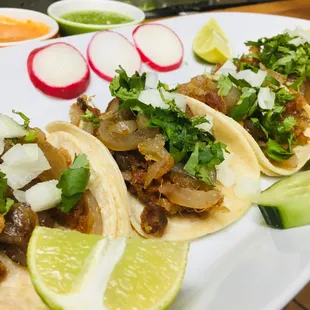 three tacoss on a white plate